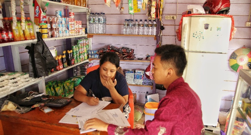 Wajib Pajak yang memiliki usaha perdagangan sembako sedang menandatangani tanda terima undangan