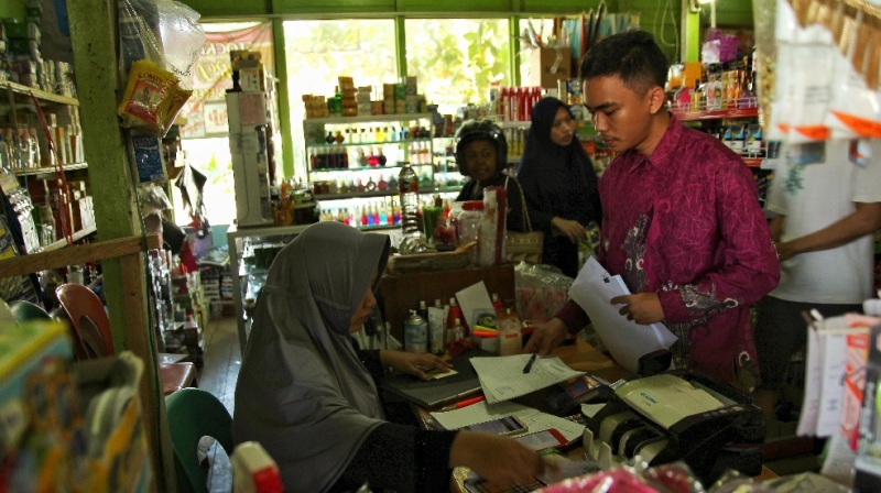 Wajib Pajak yang memiliki usaha perdagangan sembako dan berbagai keperluan rumah tangga sedang menandatangani tanda terima undangan