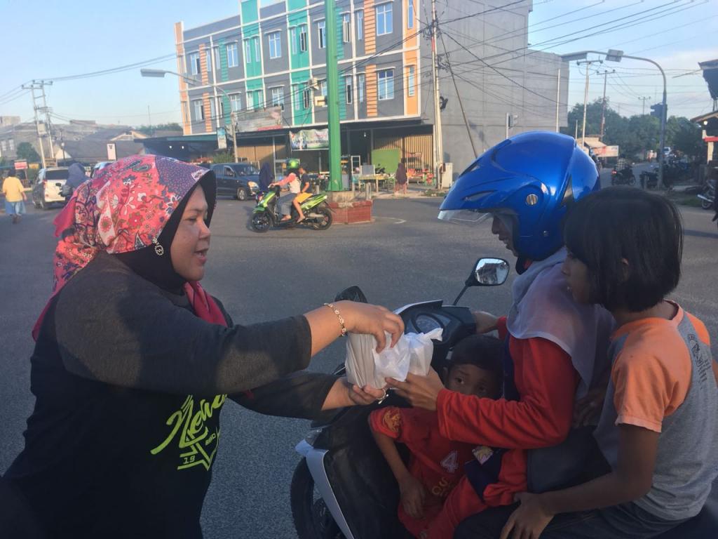 Pengendara sepeda motor di Tanjung Uban menerima makanan berbuka puasa