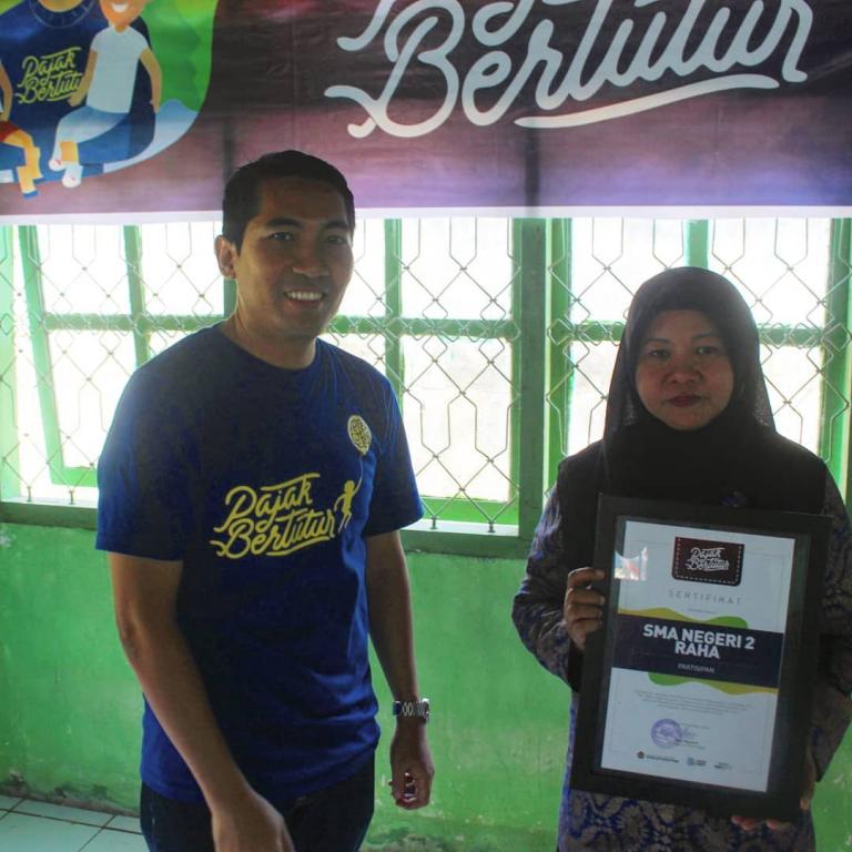 Plt. Kepala KP2KP Raha, Yusuf Mawardi, memberikan sertifikat Pajak Bertutur kepada perwakilan dari pihak SMA Negeri 2 Raha