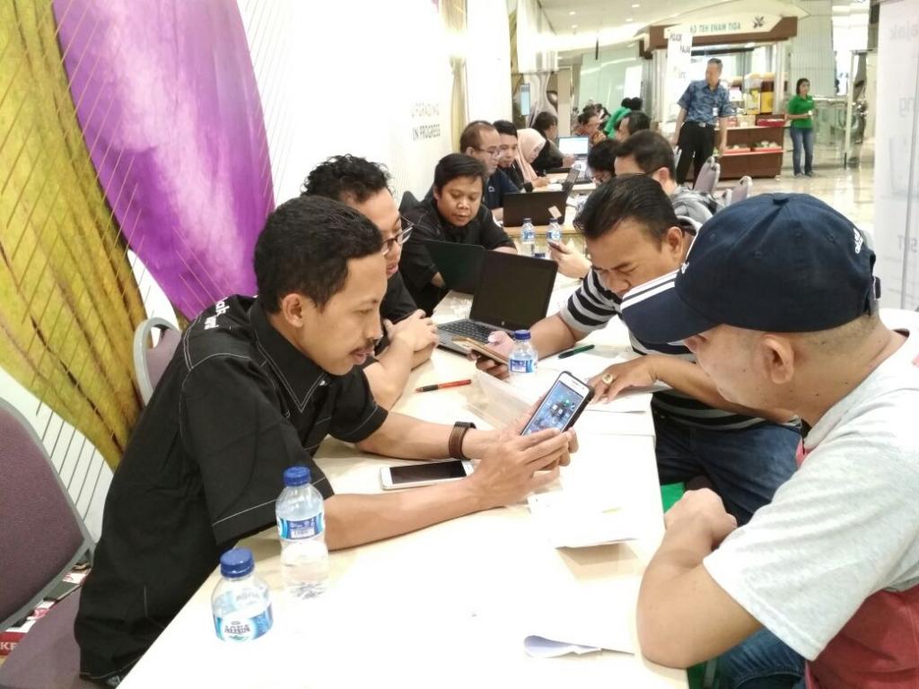 Petugas mengajari WP cara lapor via e-filing dengan menggunakan handphone