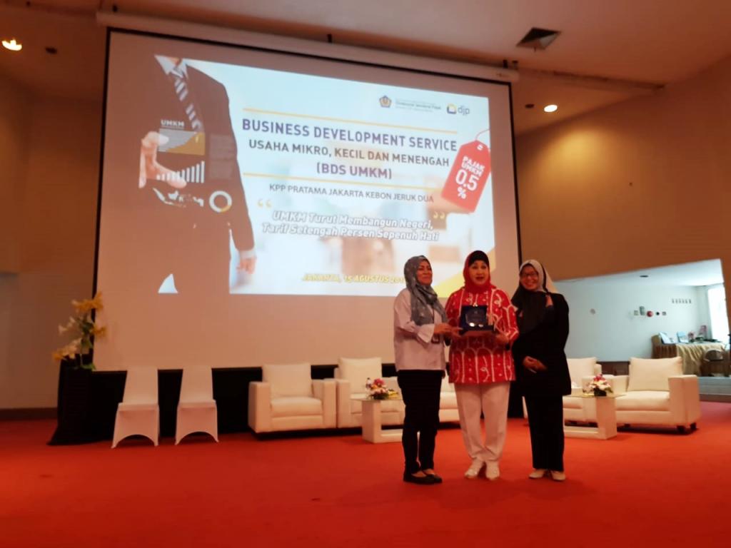 Pemberian Plakat dari Kepala KPP Kebon Jeruk Dua kepada DR. Dewi Motik Pramono didampingi Kabid P2Humas Jakarta Barat