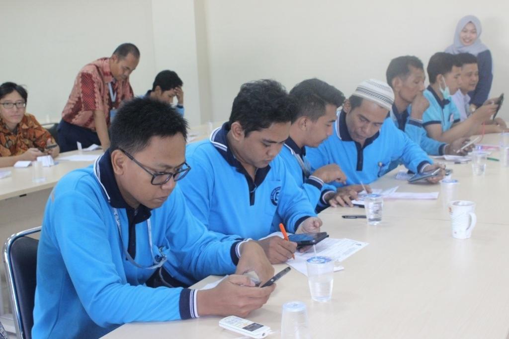 Para karyawan melakukan pengisian e-filing secara bersama-sama menggunakan alat komunikasi masing-masing