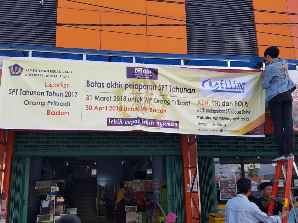 Proses Pemasangan Spanduk di Pusat Perdagangan di Pulau Sebatik