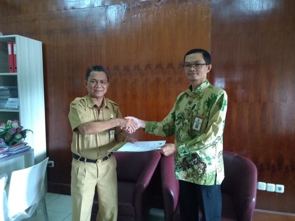 Kepala KPP Pratama Manokwari berjabat tangan usai penandatanganan perjanjian kerjasama dengan Kepala Dinas PTSP dan PM Kabupaten Manokwari