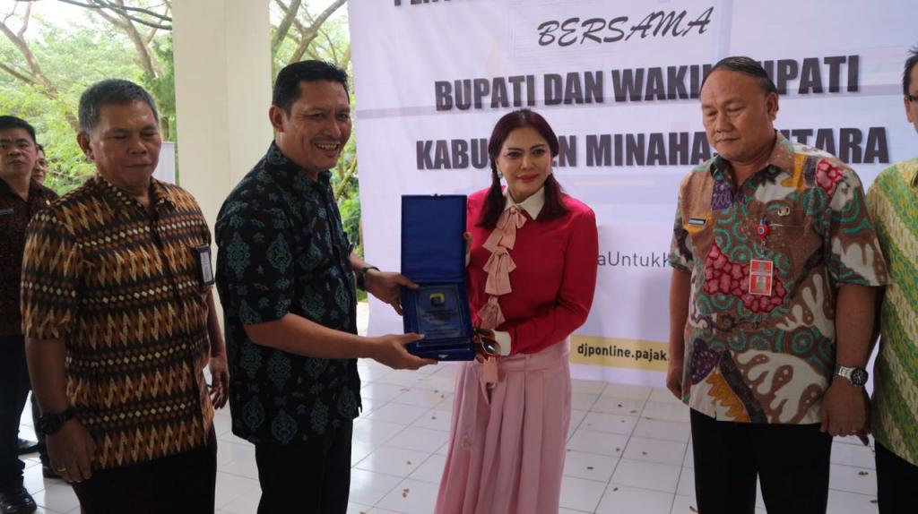 Kepala KPP Pratama Bitung menyerahkan Cinderamata kepada Bupati Minahasa Utara