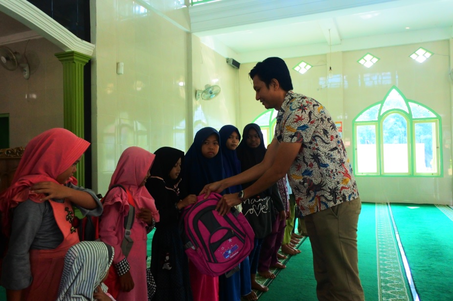 Kepala KP2KP Baradatu menyerahkan bingkisan berupa perlengkapan sekolah kepada anak-anak yatim di lingkungan Masjid Muslimin Kecamatan Baradatu.