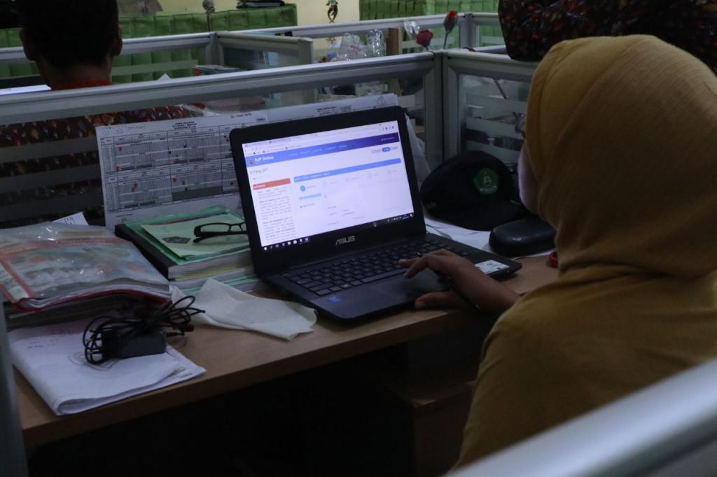 Salah seorang guru sedang mengakses aplikasi e-filing dengan laptop pribadinya