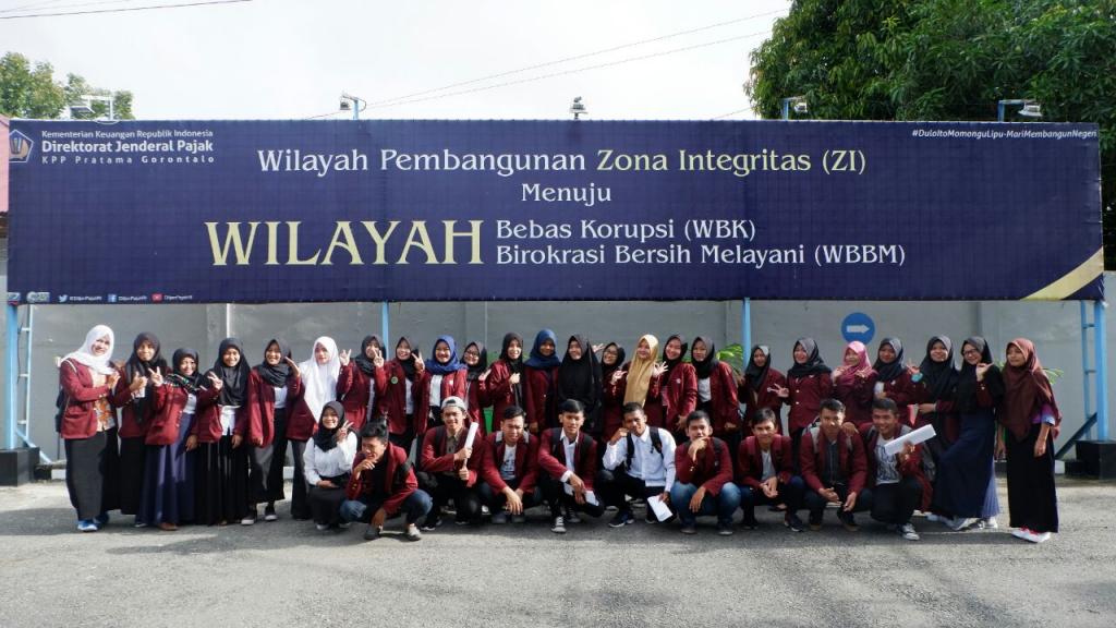 Foto bersama mahasiswa dibawah baliho “Zona Integritas Menuju Wilayah Bebas Korupsi”