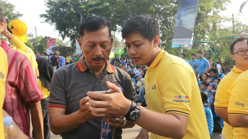 Pegawai pajak memberikan bimbingan pelaporan SPT Tahunan melalui efiling dengan gawai wajib pajak