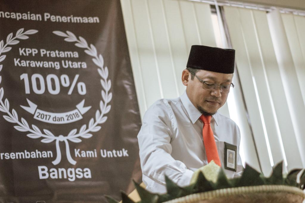 Kepala Kantor KPP Karawang Utara setelah menarik spanduk, simbol tercapainya target peneriman pajak 2018