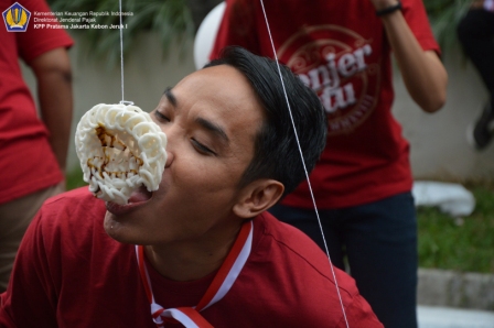 Pak Eko memakan kerupuk dengan semangat