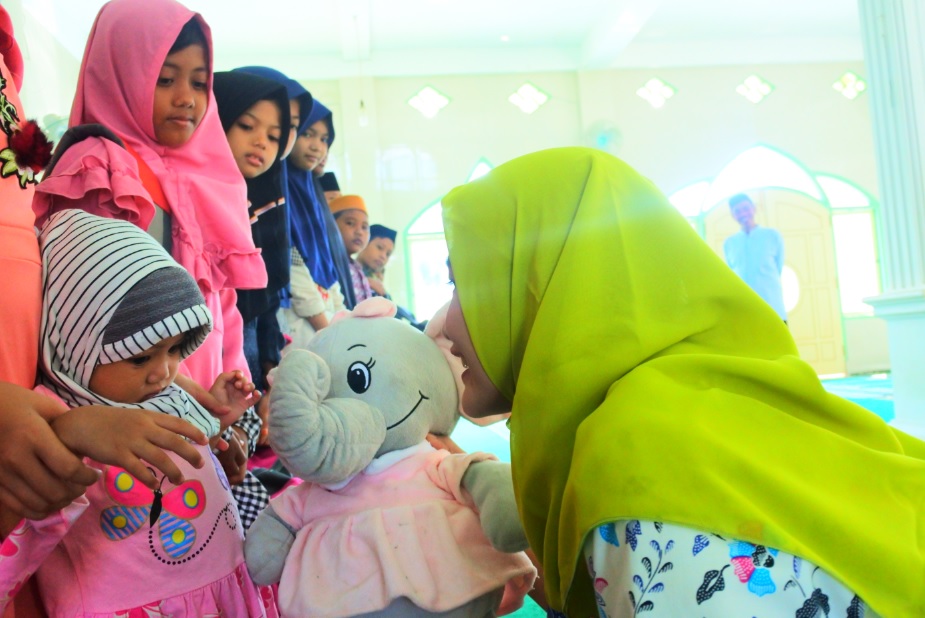 Pegawai KP2KP Baradatu menyerahkan boneka kepada salah satu anak yatim.